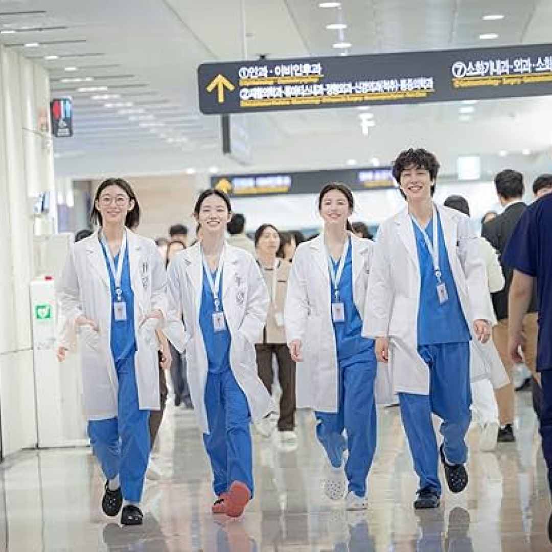 Four doctors walk down a crowded hallway, in 'Resident Playbook.'